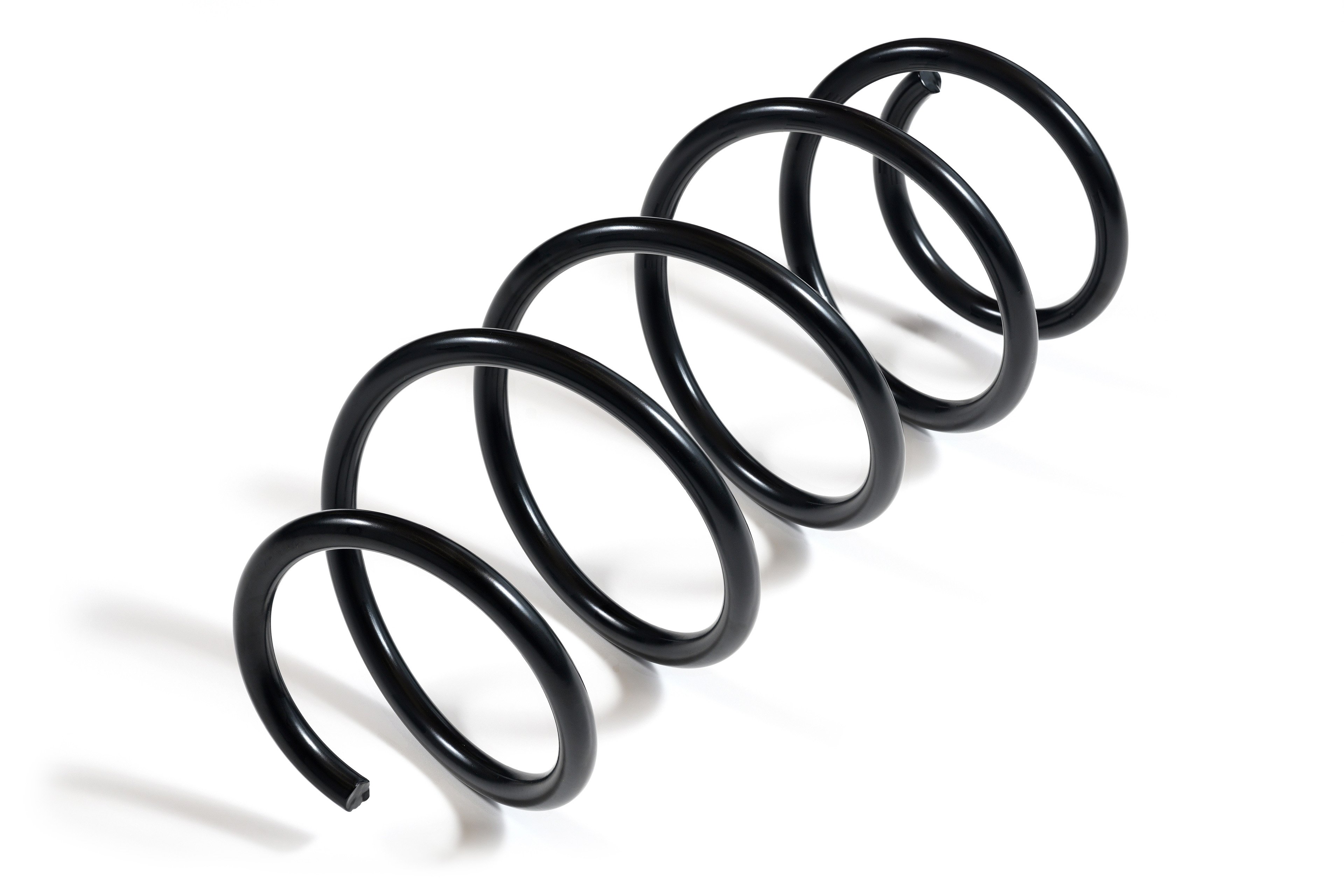 Ein schwarzer Druckfeder aus Metall mit glänzender Oberfläche ist vor einem weißen Hintergrund fotografiert. Die Feder windet sich gleichmäßig spiralig.