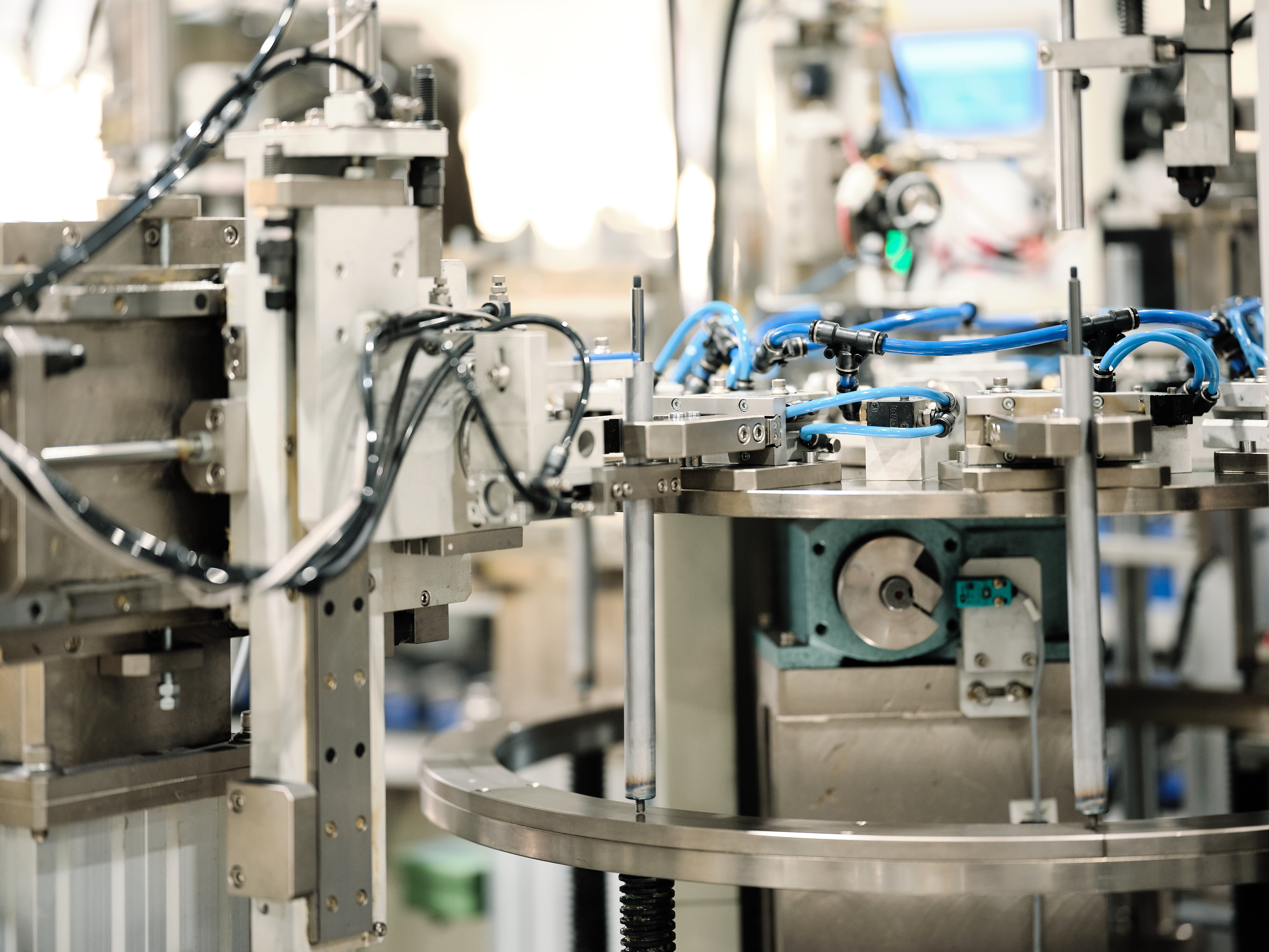 Nahaufnahme einer modernen Industriemaschine mit miteinander verbundenen Kabeln und Metallkomponenten, die Gasfedern herstellt.