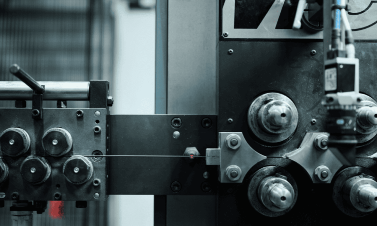 Nahaufnahme einer Industriemaschine mit mehreren Zahnrädern und Hebeln, mit Fokus auf die Metallkomponenten.