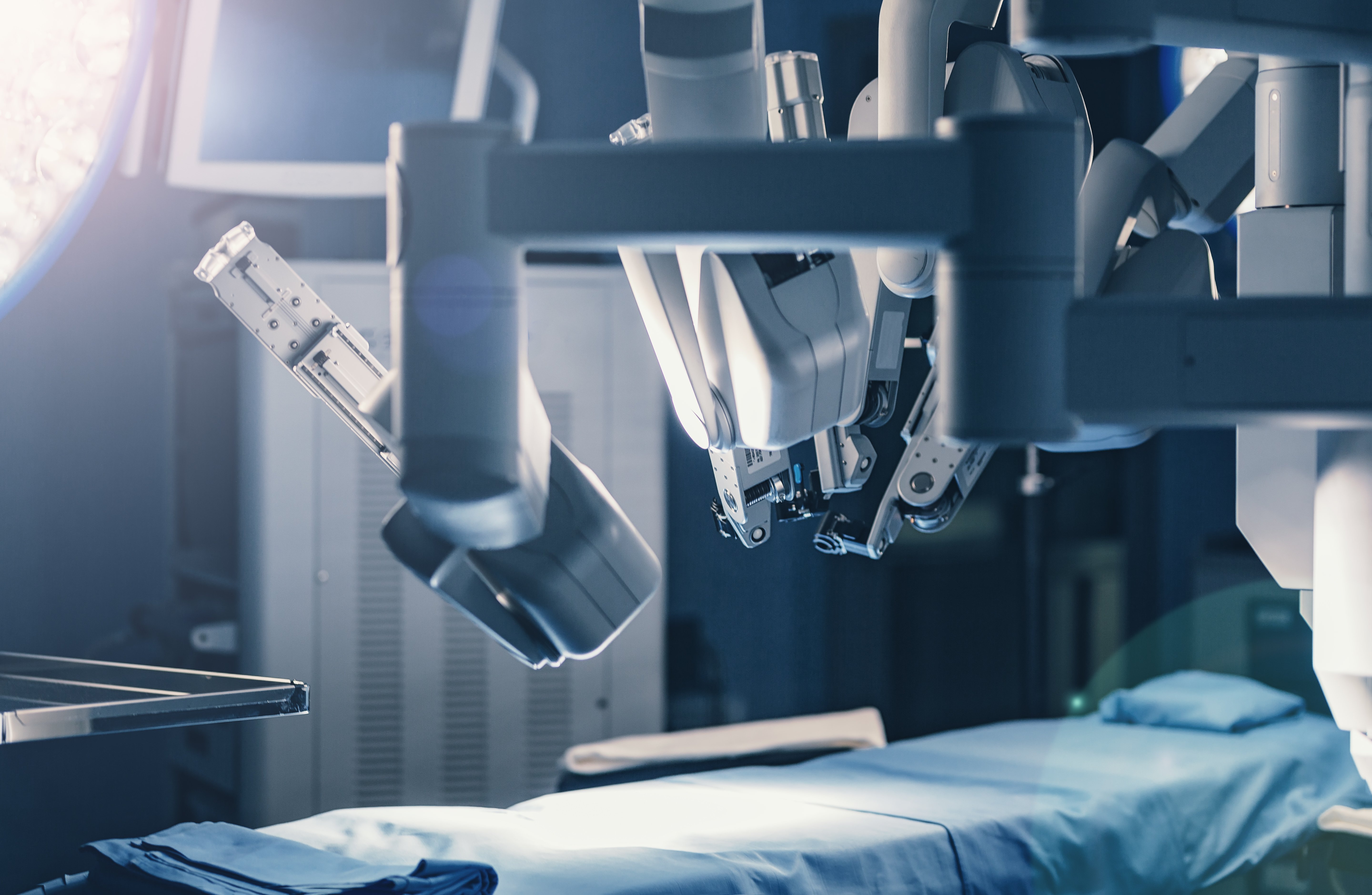 A surgical medical robot that uses constant force springs, above a patient bed.