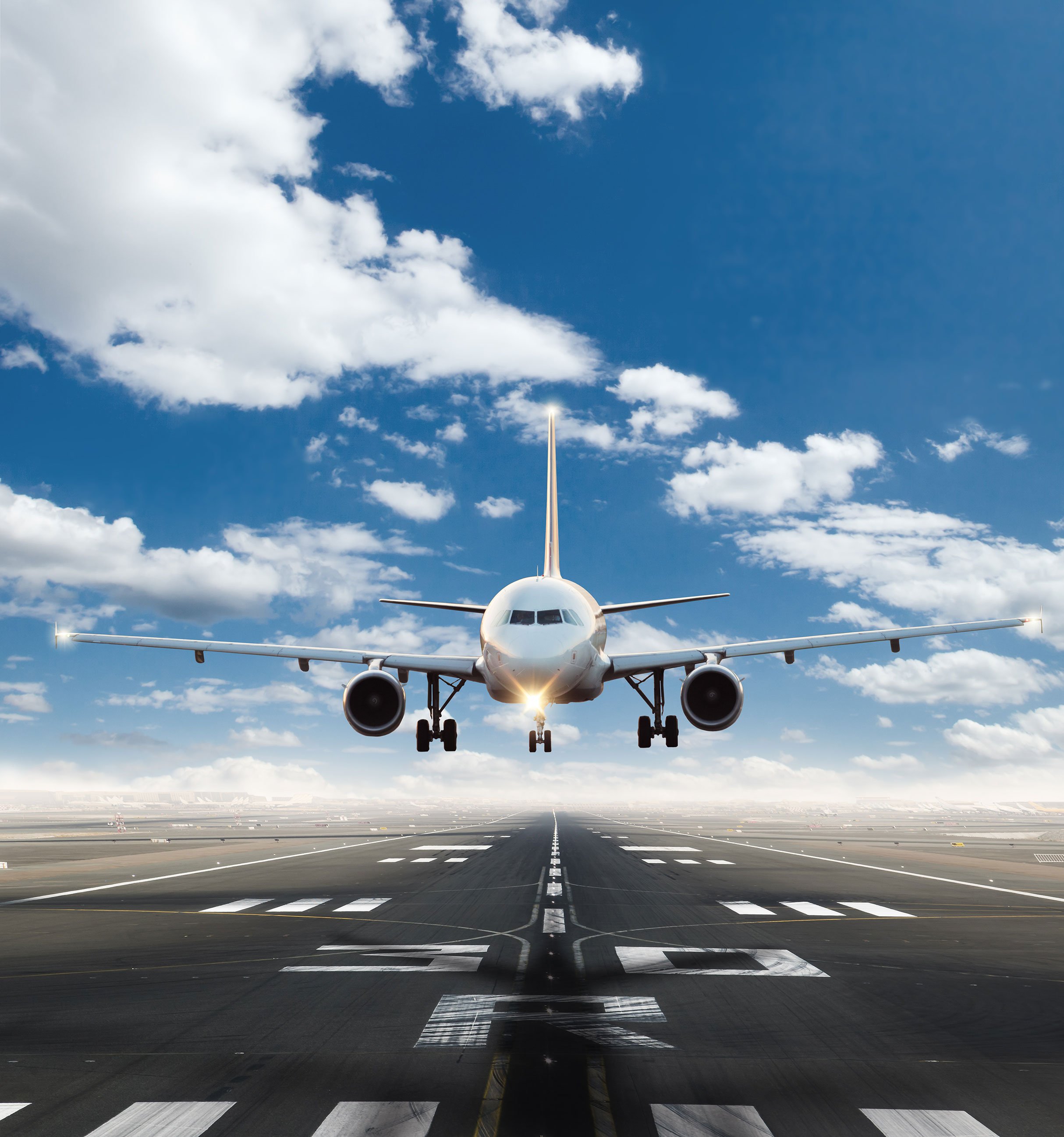 Ein Passagierflugzeug landet auf einer Landebahn vor blauem Himmel und steht für reale Luftfahrtanwendungen von Lesjöfors Federn und Komponenten.