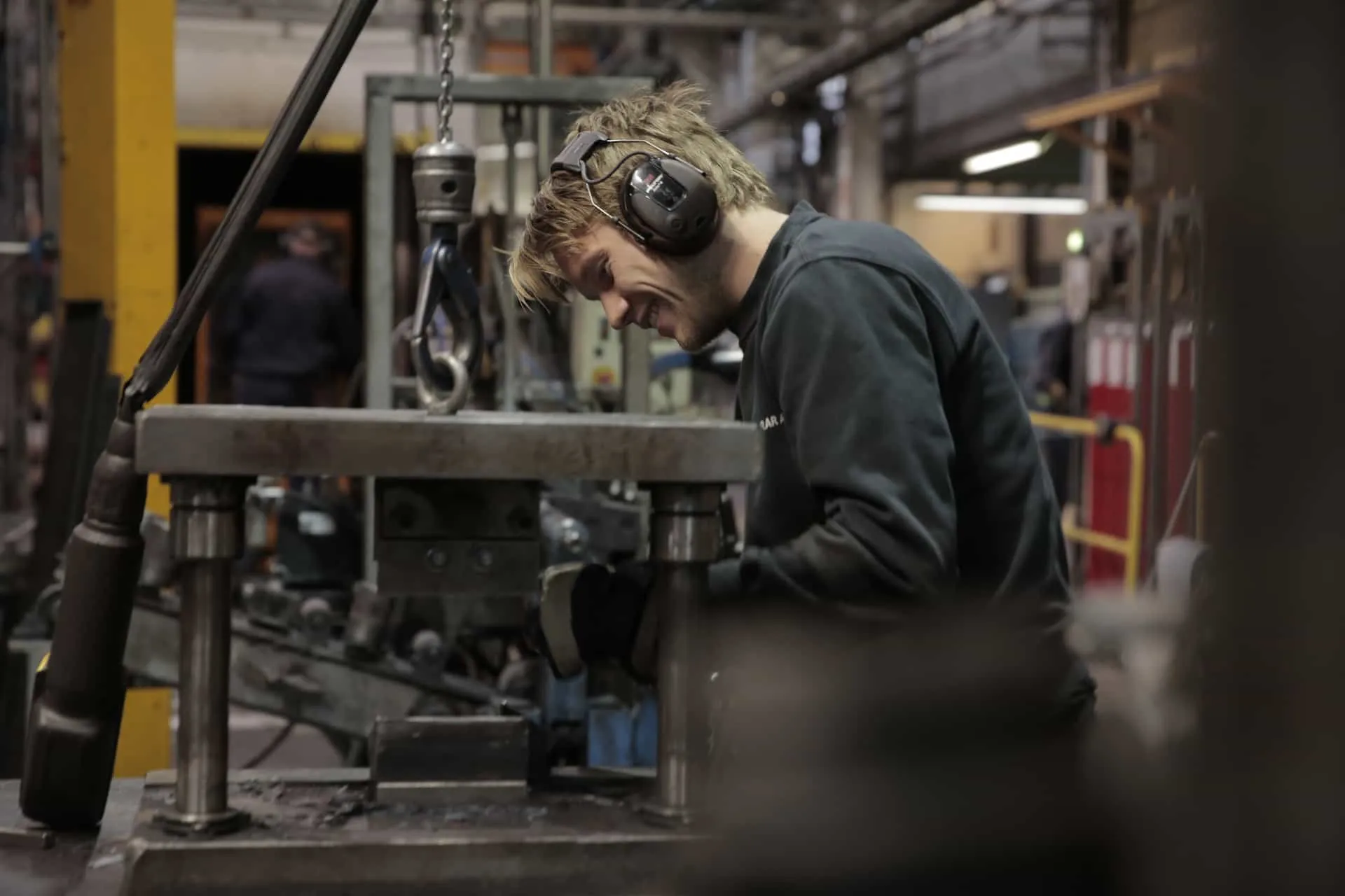 An engineer wearing protective gear works on machinery during the spring design process in a Lesjöfors’ manufacturing facility.