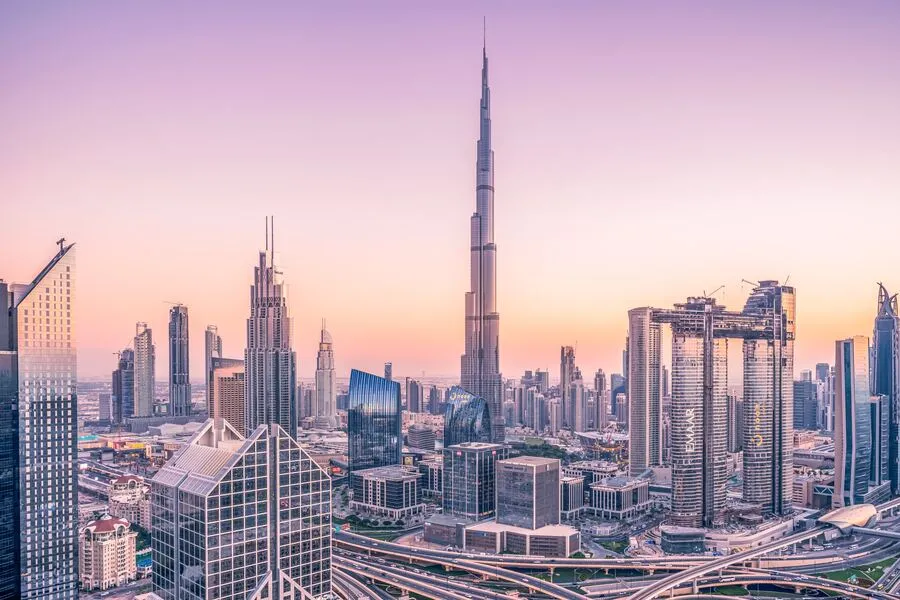 Dubai skyline at sunset featuring the Burj Khalifa and modern skyscrapers.