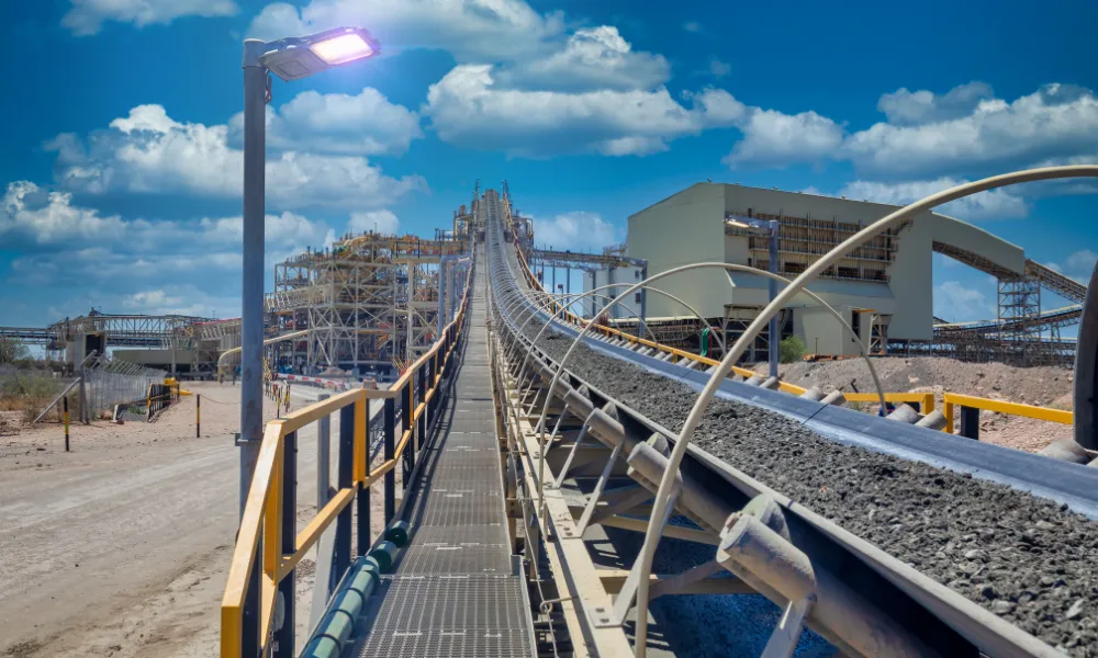 Industrielles Förderband, das Gesteinsmaterial zu einer Verarbeitungsanlage in einer Bergbauanlage transportiert.