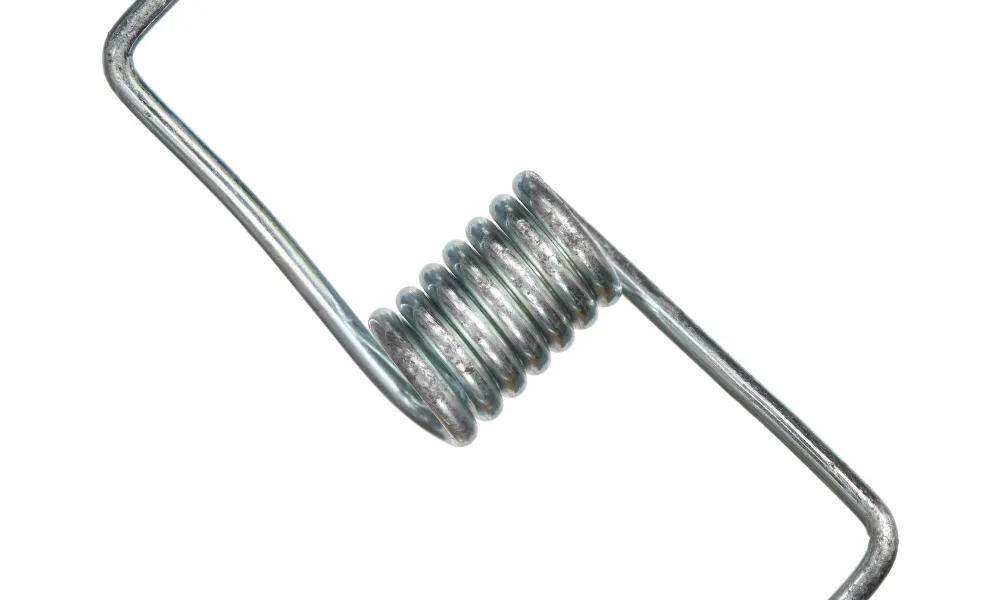 Nærbilde av en tett viklet, metallisk sølvfarget torsjonsfjær mot en hvit bakgrunn, som fremhever dens glatte spiraldesign og blanke overflate.