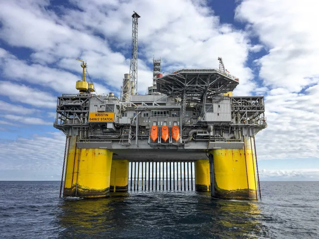 Große Offshore-Öl- und Gasplattform, getragen von einer Unterwasserstruktur im offenen Ozean bei Tageslicht.