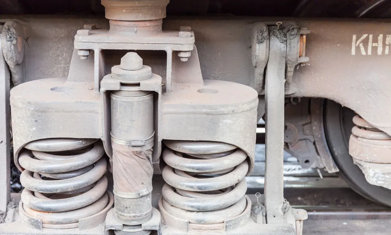 Close-up of heavy-duty coil springs in a railway bogie suspension system.