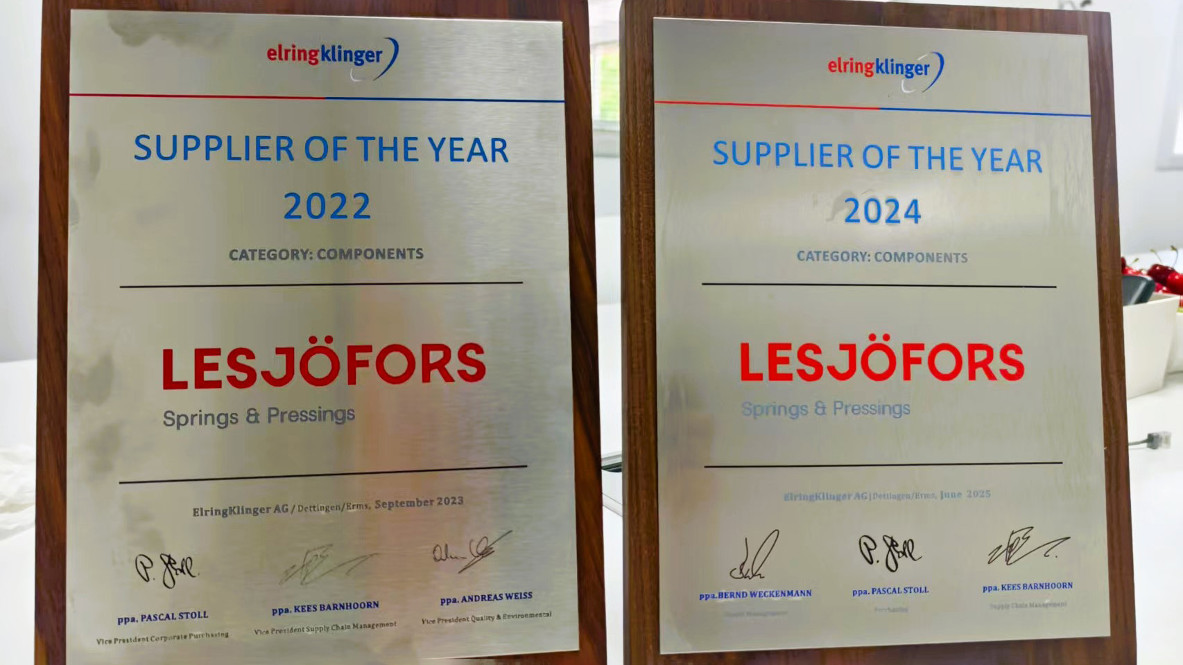 Zwei Plaketten mit der Aufschrift „Supplier of the Year“ für 2022 und 2024, verliehen an Lesjöfors Springs & Pressings. Die Plaketten sind nebeneinander ausgestellt.