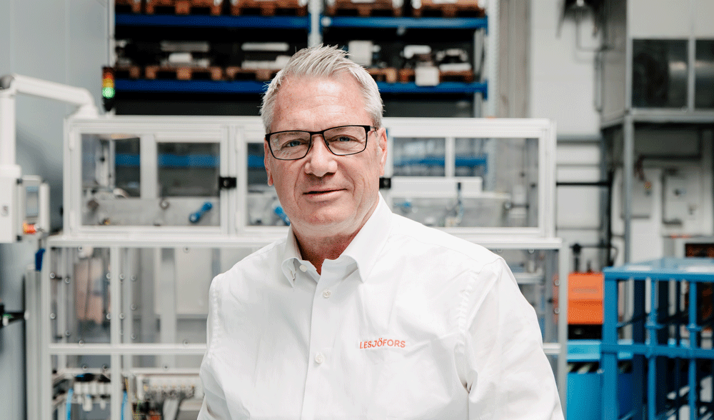 Thomas Griese wearing a white shirt in front of a production facility.