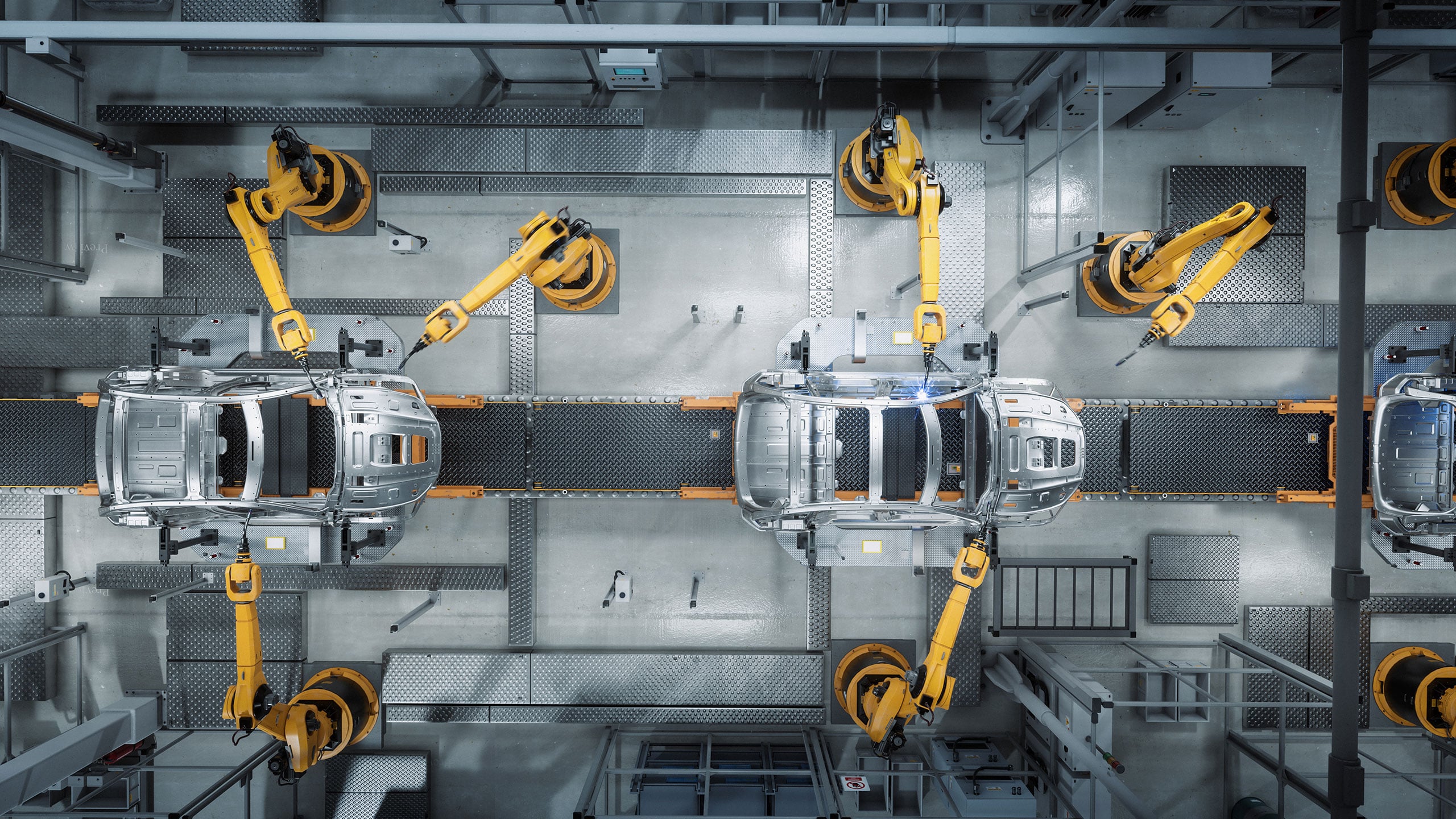 Draufsicht auf Roboterarme, die Karosserien auf einer Automobil-Montagelinie zusammenbauen.