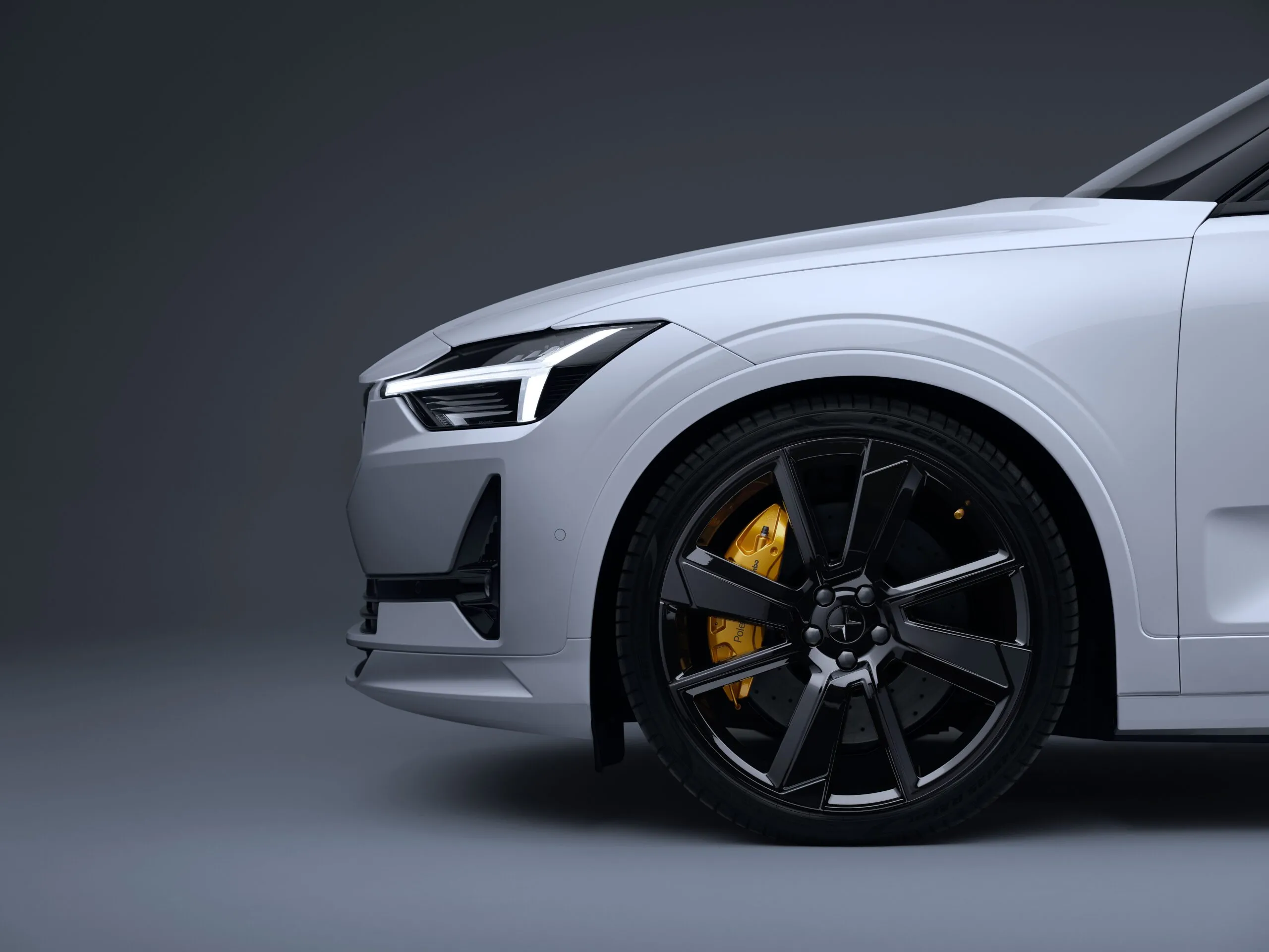 Side view of the bonnet and front left wheel of a white Polestar 2.