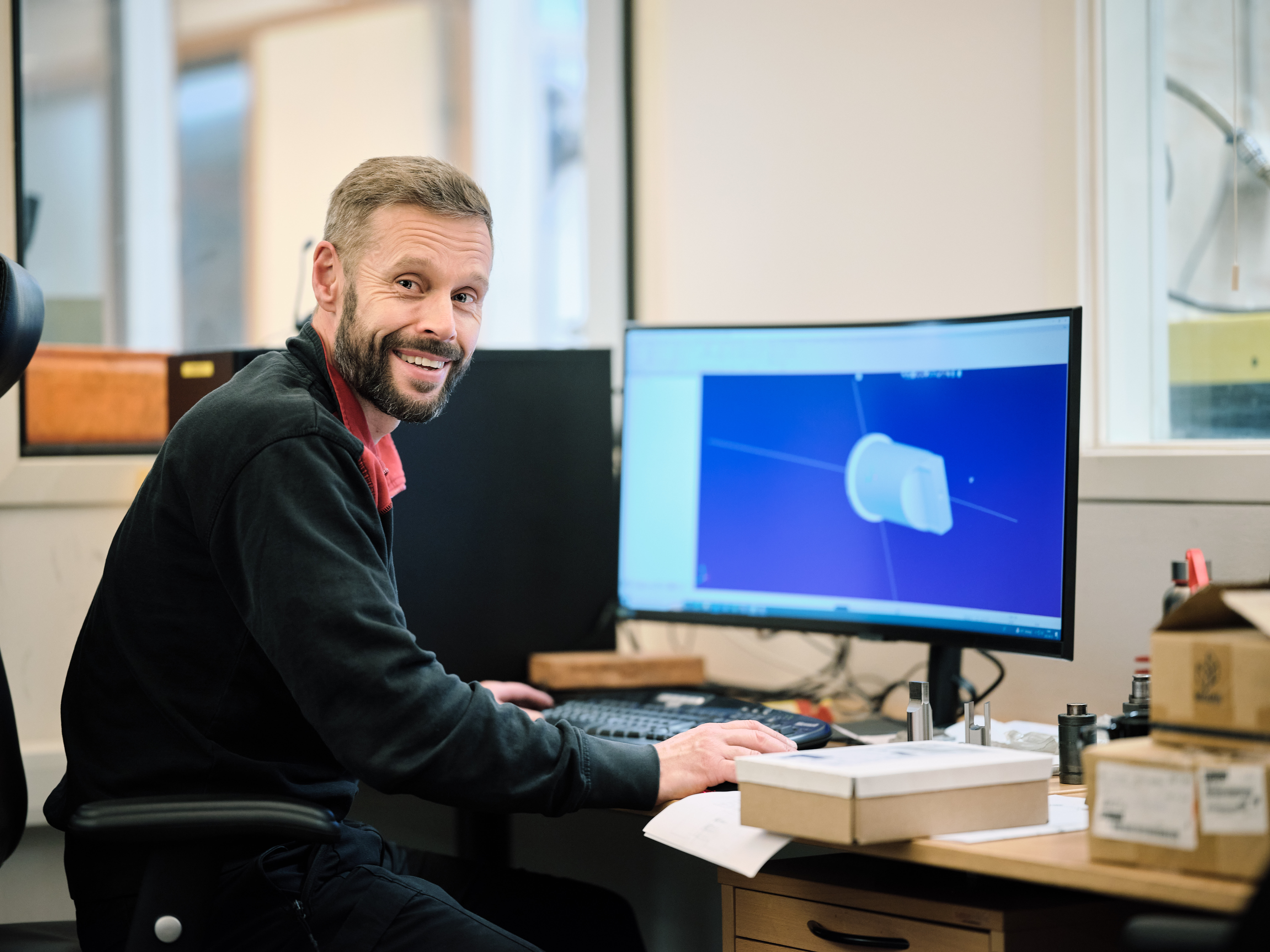 Ein Ingenieur arbeitet am Computer und entwirft ein 3D-Modell eines Metallbauteils.