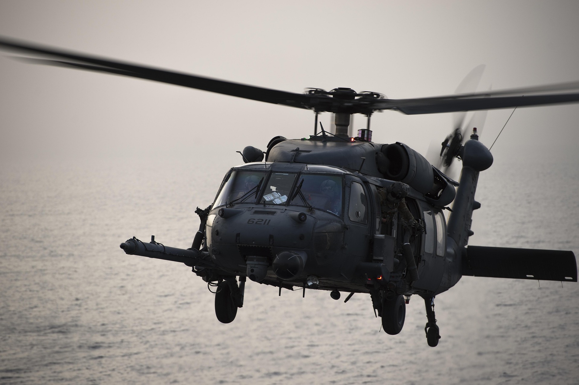 Militærhelikopter flyver lavt over havet. 